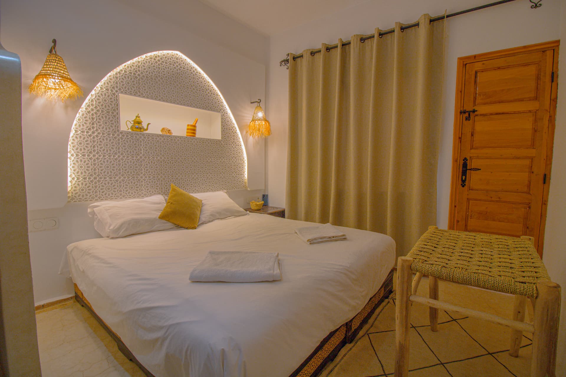 ANZAR — wide view of the bedroom with lit carved arch headboard