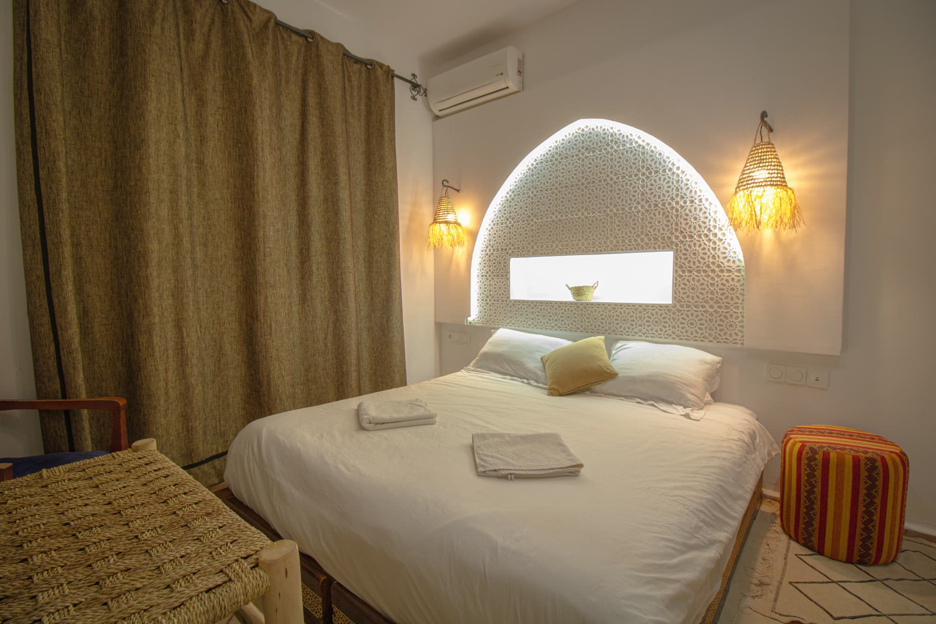 WARROU — bedroom detail with lantern sconces and woven bench