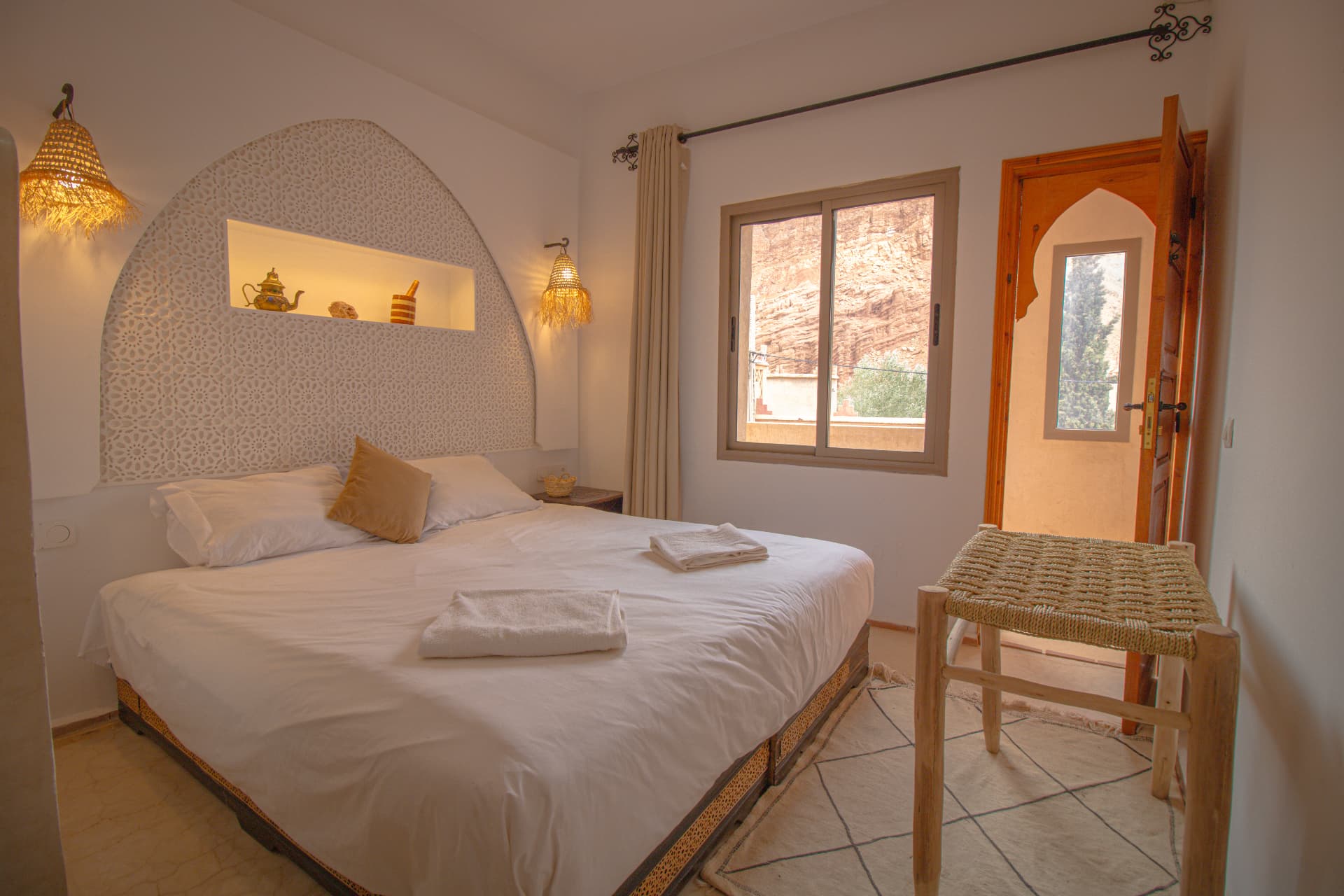 ANZAR — bed beneath the carved arch with window onto the canyon