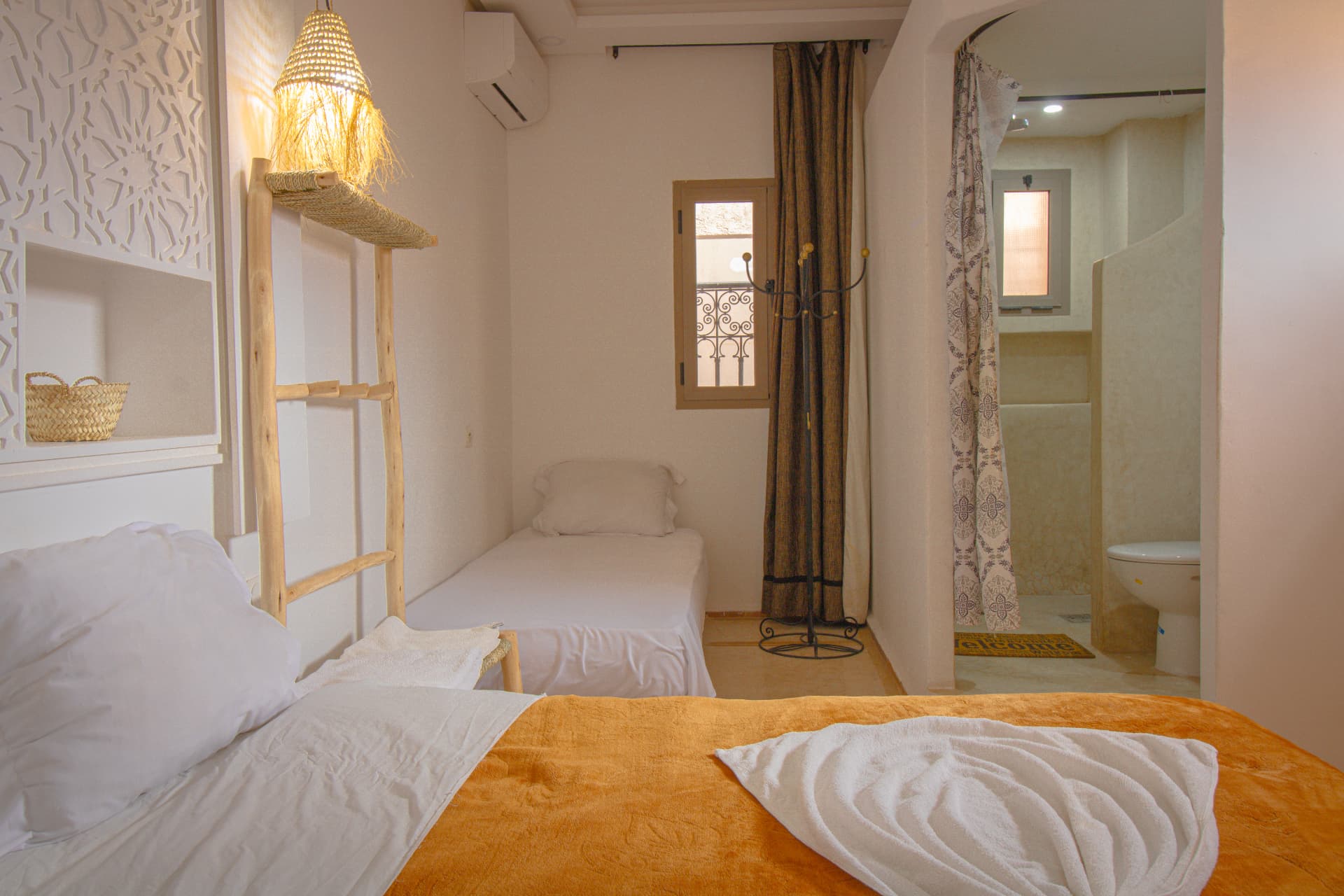 DADES — single bed by the window with view through to the bathroom
