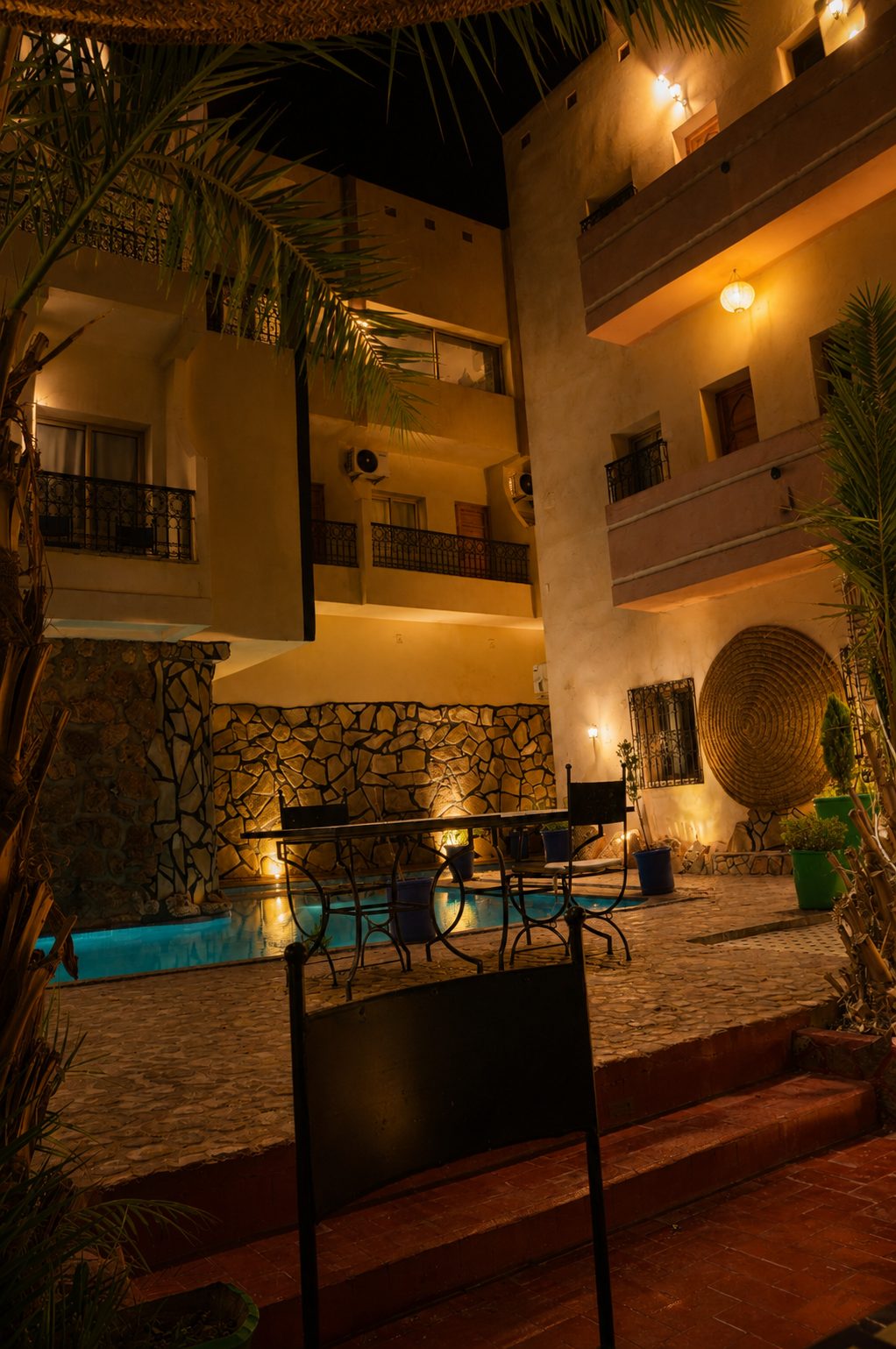 Lantern-lit courtyard and swimming pool at night at Riad Canyon Dades guesthouse