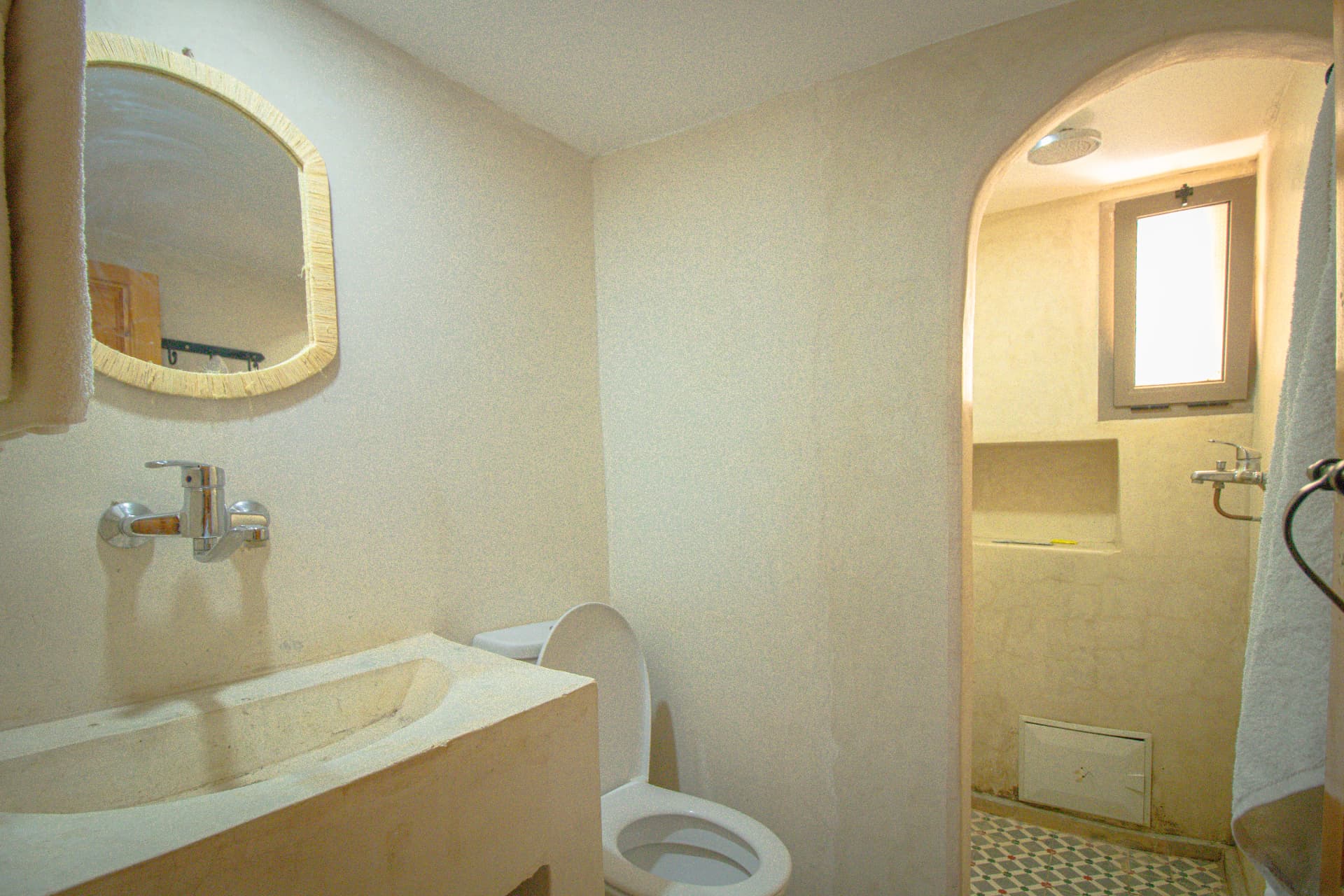 AMENTI — tadelakt bathroom with carved sink and arched shower
