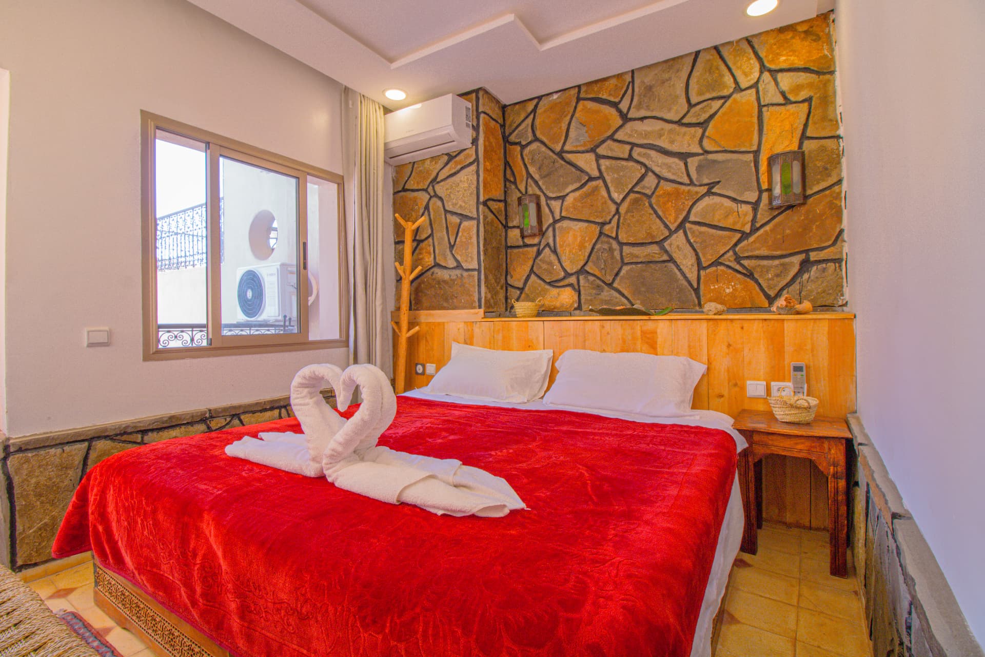 DRAA — double bed beneath the stone wall with lanterns and balcony window