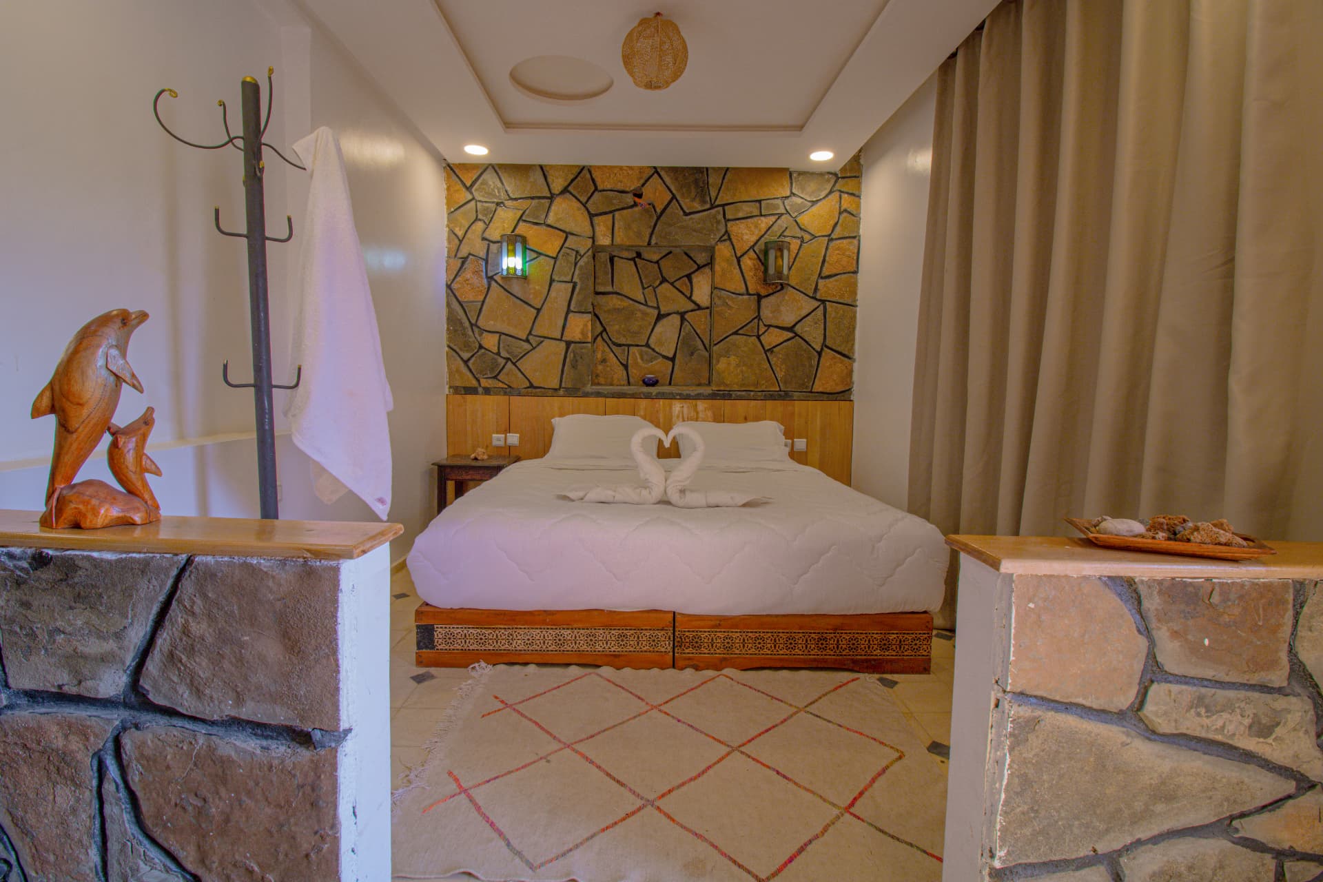 TAFUKTE — bed beneath the stone feature wall and lanterns