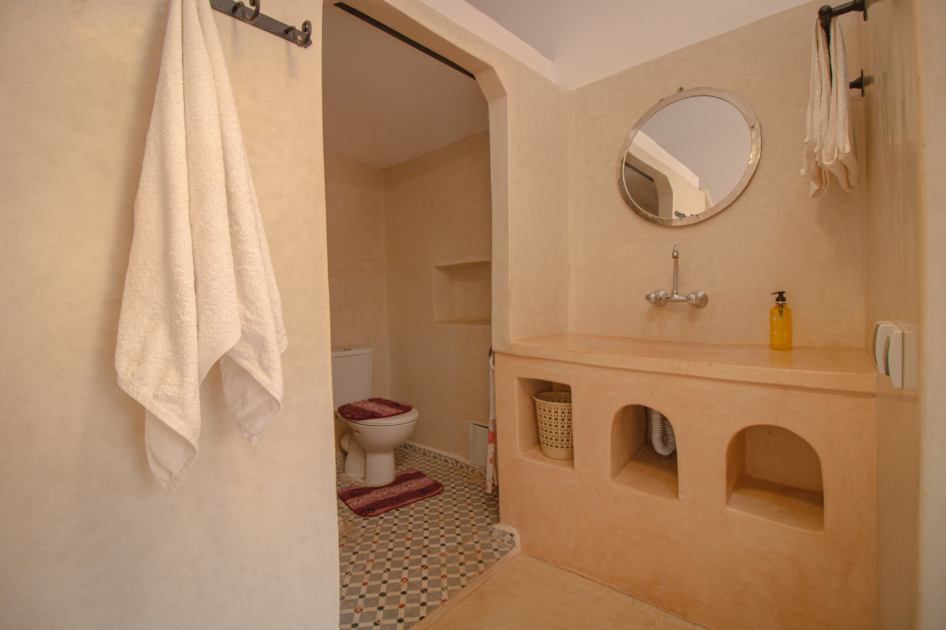 ANZAR — tadelakt bathroom with round mirror and alcoves
