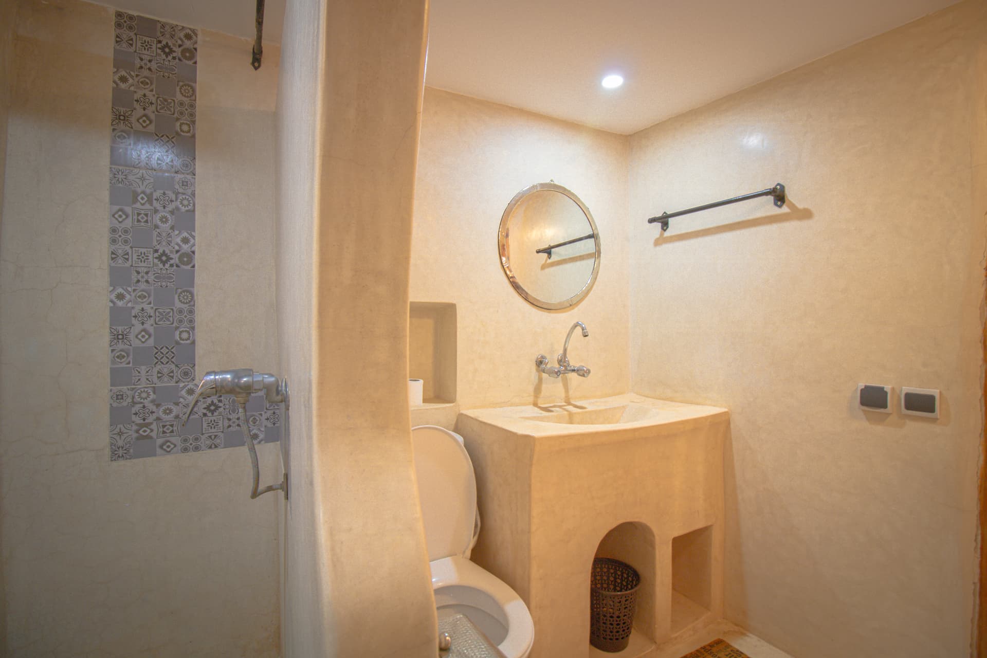 TIRIT — tadelakt bathroom with round mirror and carved sink
