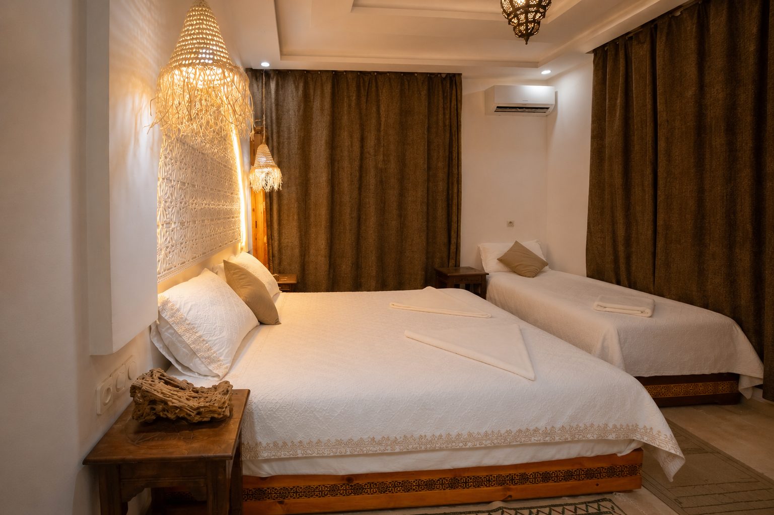 AMENTI — bedroom detail with woven pendant lamps and third bed
