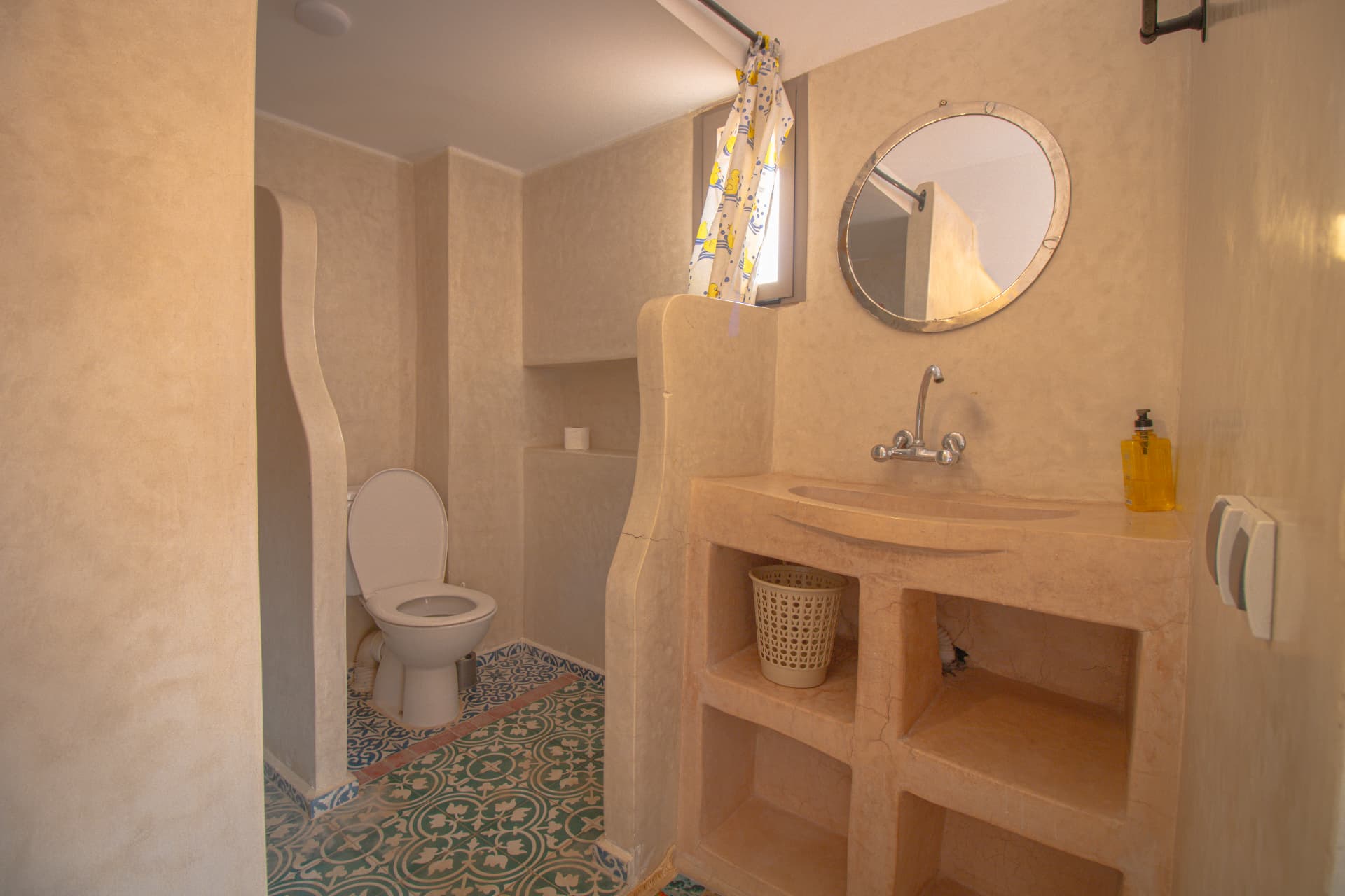 WARROU — tadelakt bathroom with round mirror and tiled floor