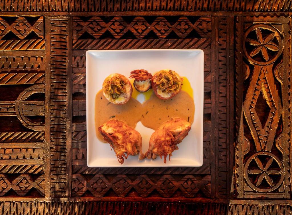 Refined Moroccan dish on a square plate over hand-carved cedar wood