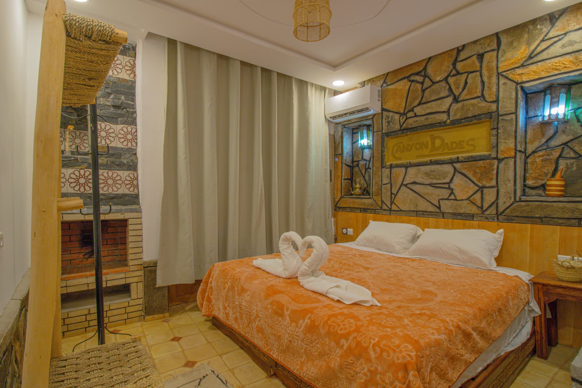 MARZOUGA — double bed beneath the carved Canyon Dades sign with stained-glass niches