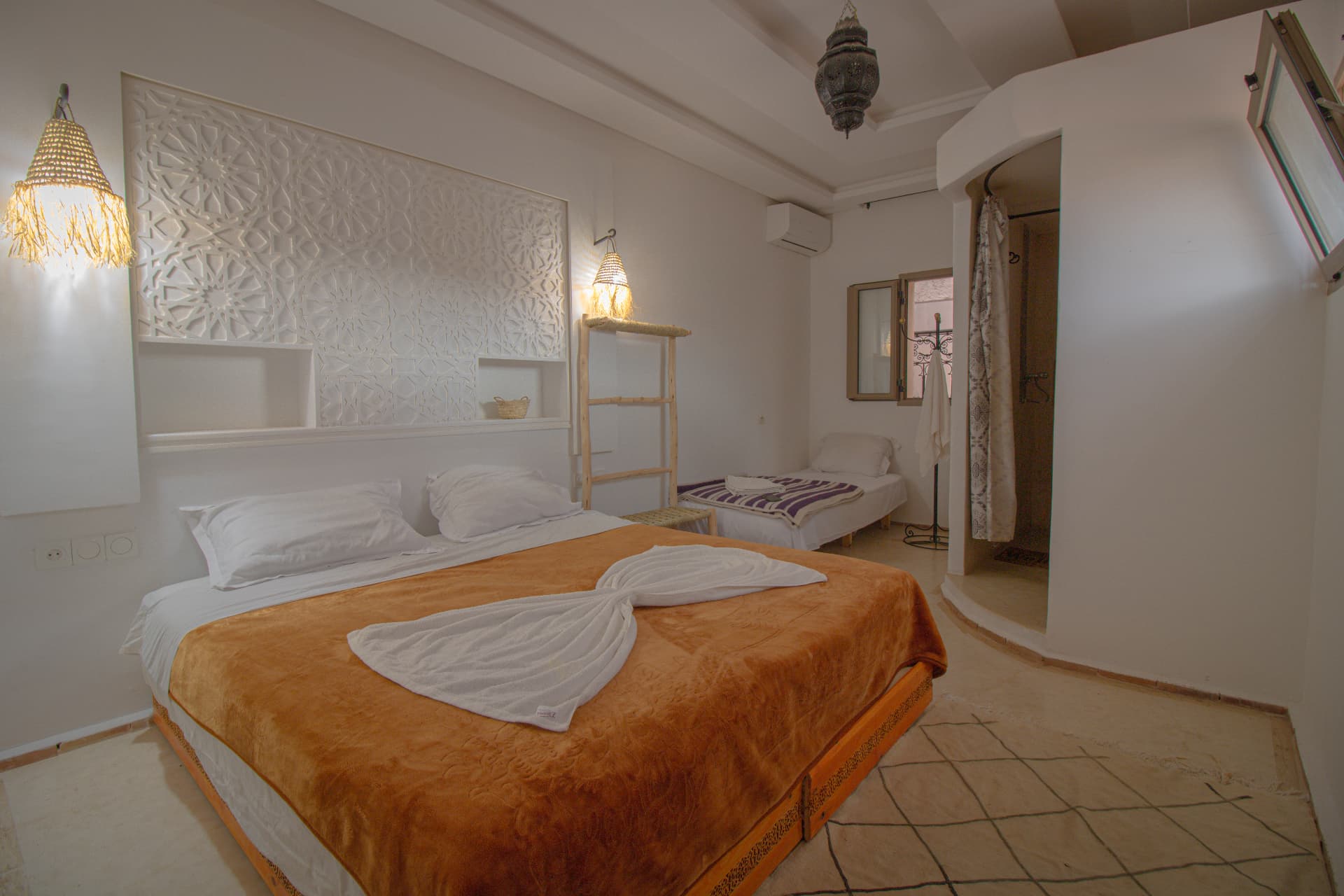 DADES — wide bedroom with carved white plaster headboard, double and single bed