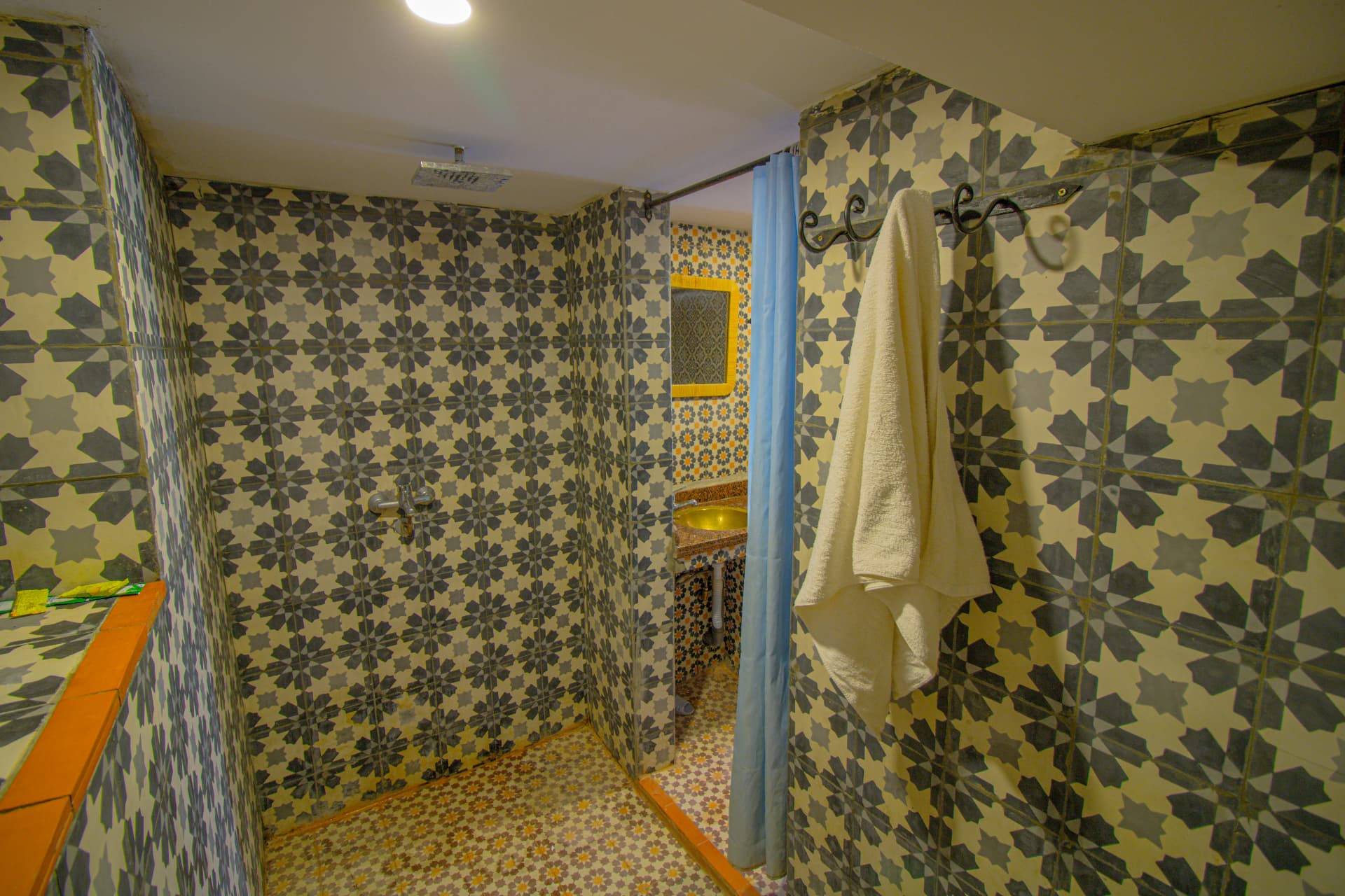 TAFUKTE — zellige-tiled bathroom with rain shower
