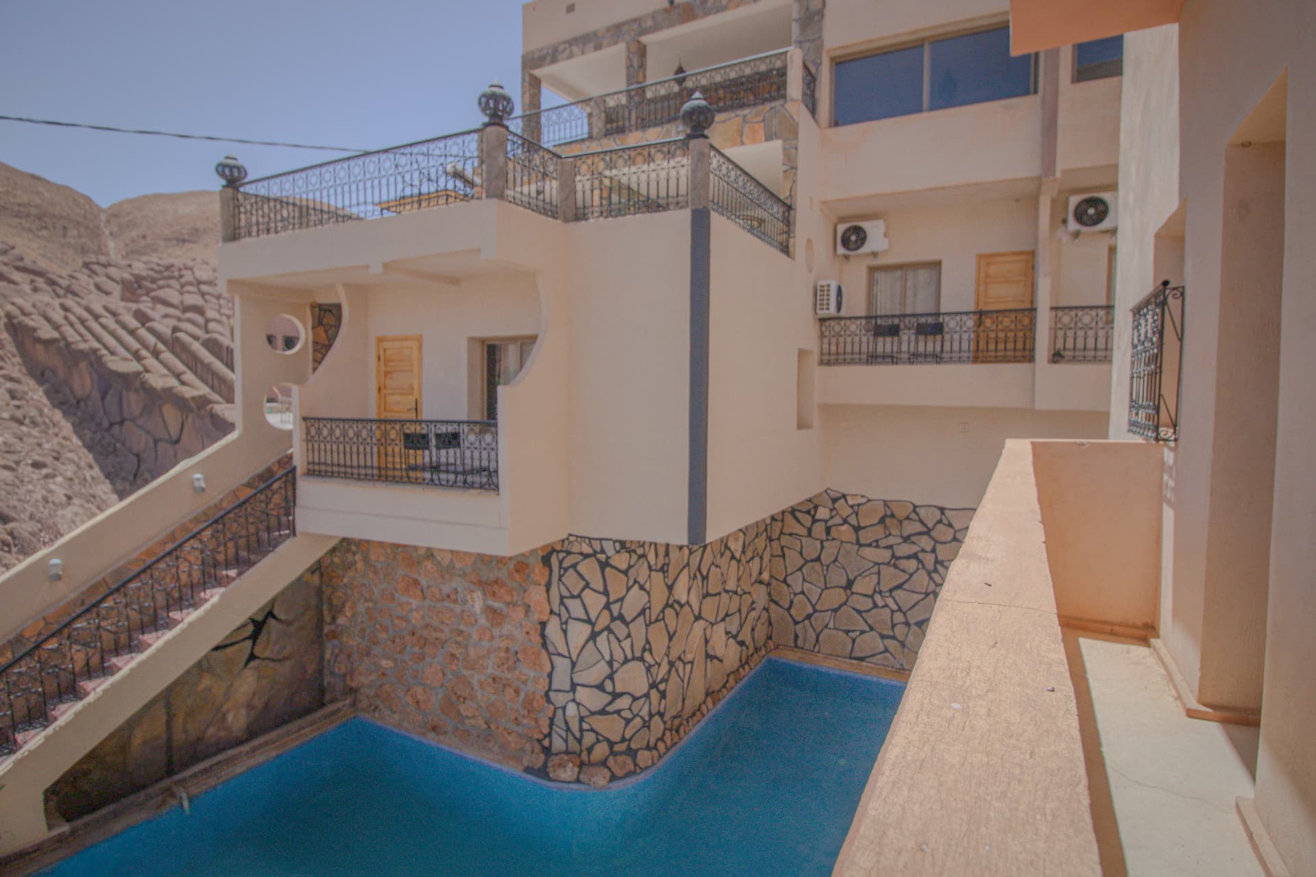 AMENTI — balcony view over the pool and canyon cliffs