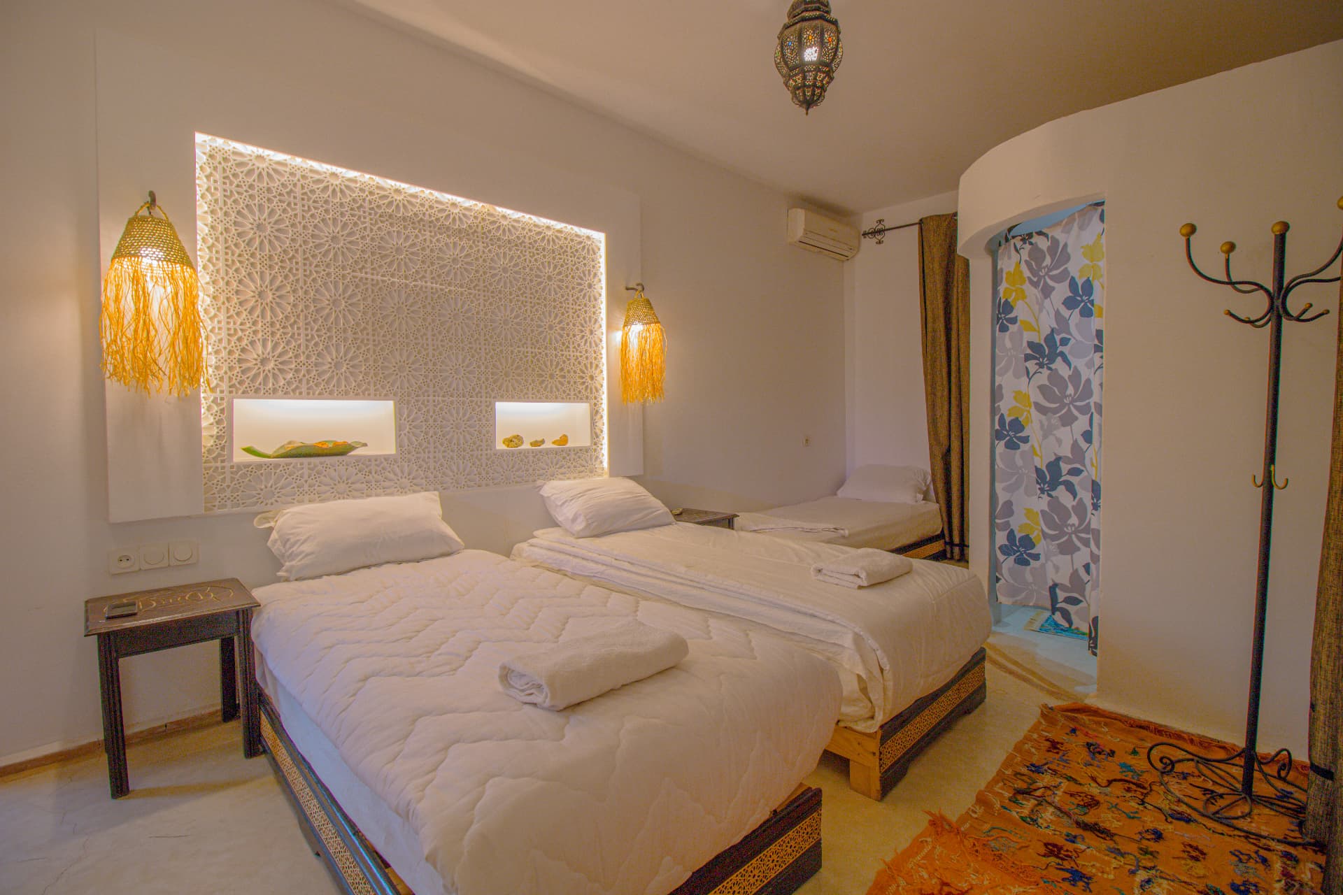 TALA — wide bedroom with illuminated carved plaster headboard, double and single bed