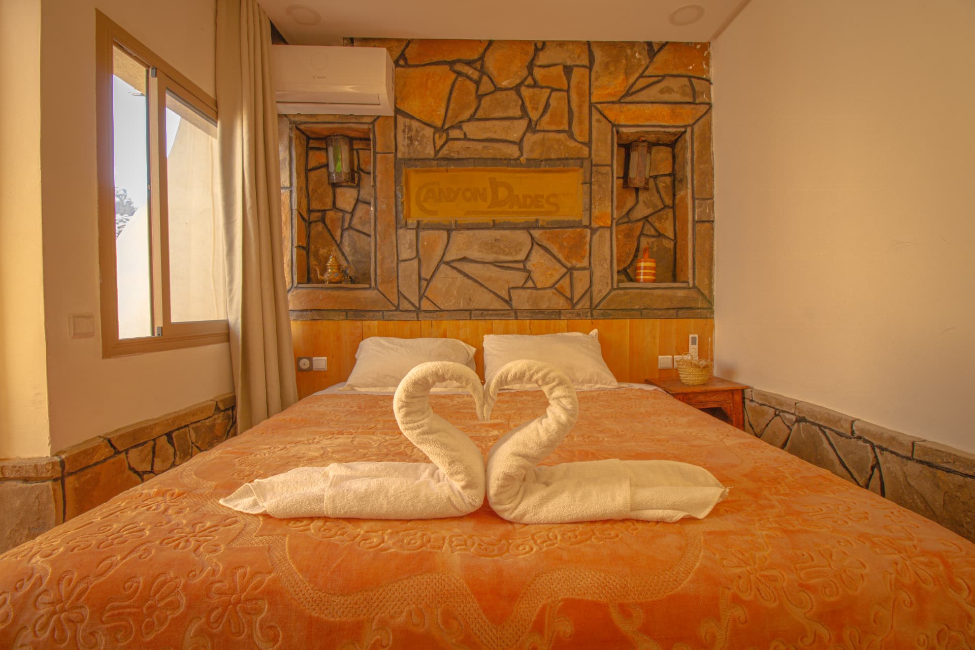 MARZOUGA — bed with towel swans, lantern sconces and window light