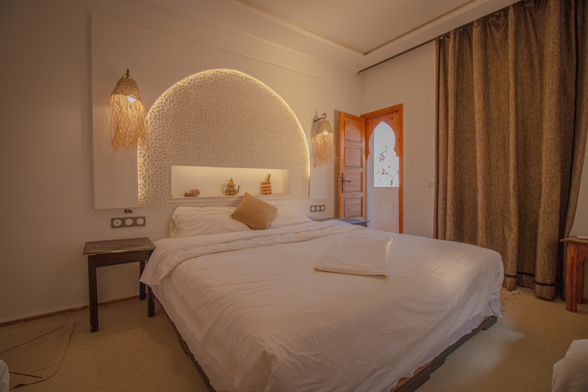 TIRIT — double bed beneath the carved arch headboard