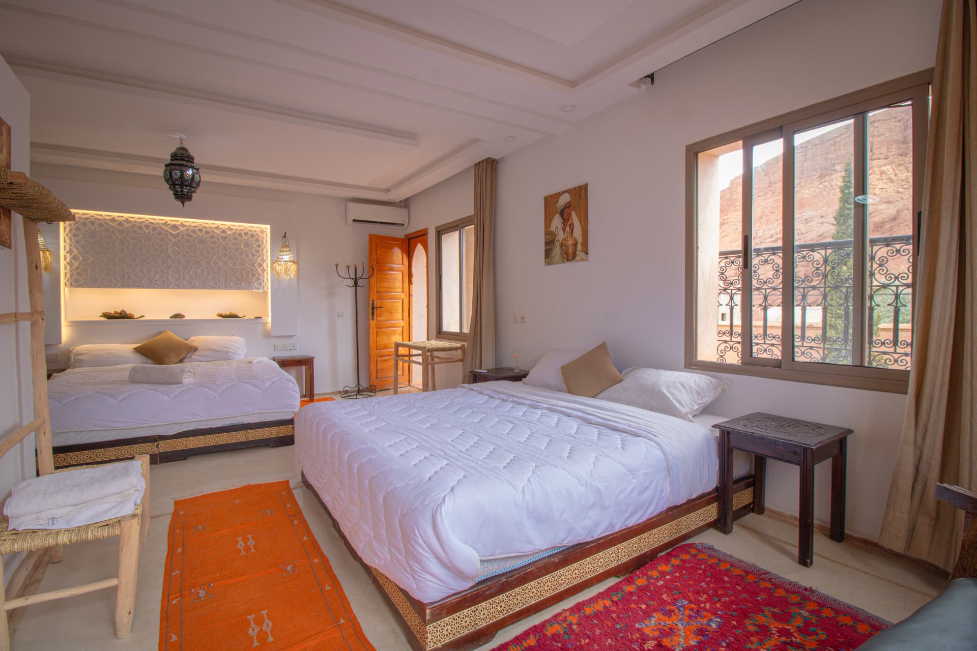 ATLAS — wide bedroom with carved headboard and canyon balcony