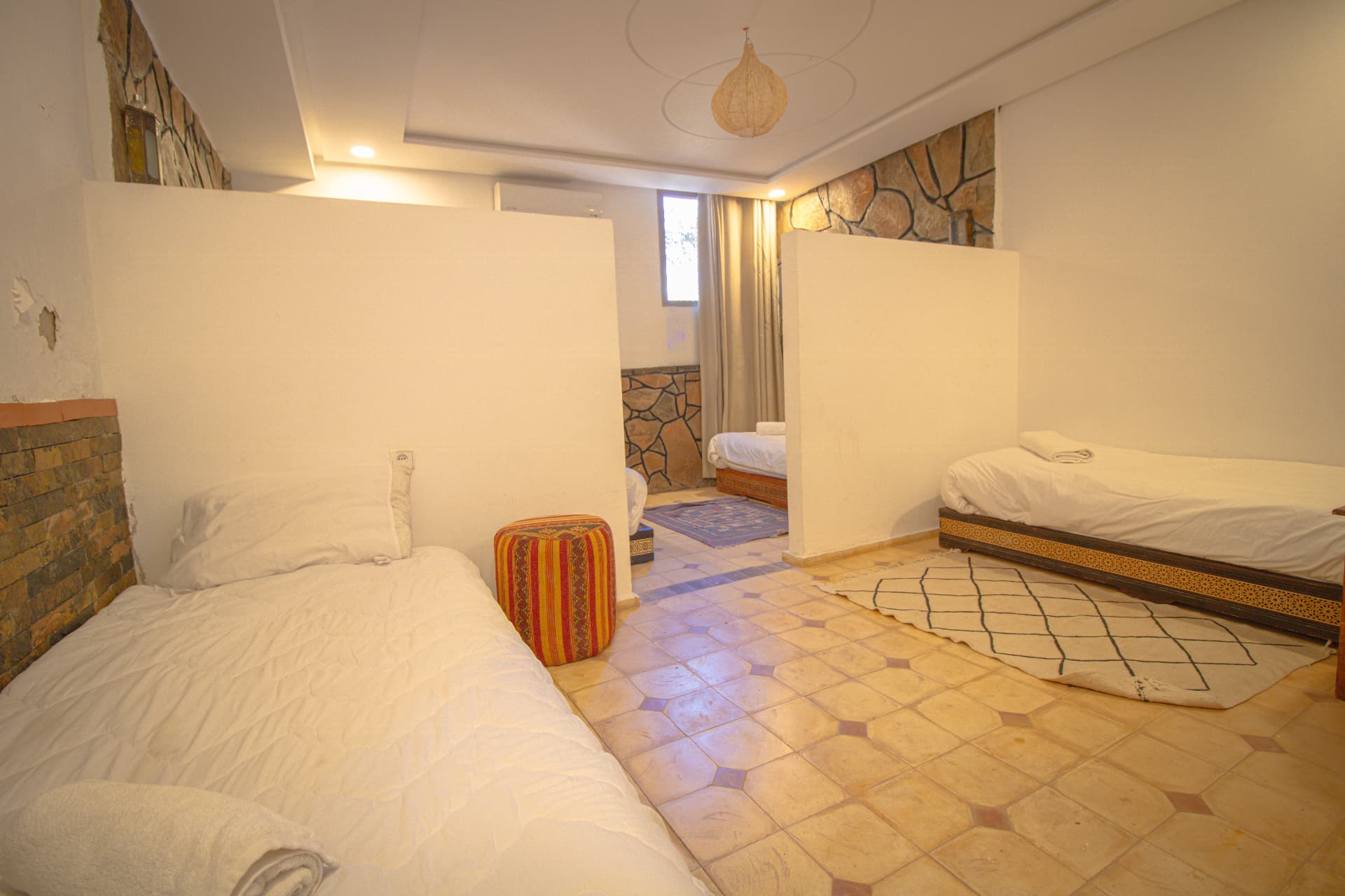TAZDYI — wide family room view with separated sleeping alcoves, Berber rugs and stone walls