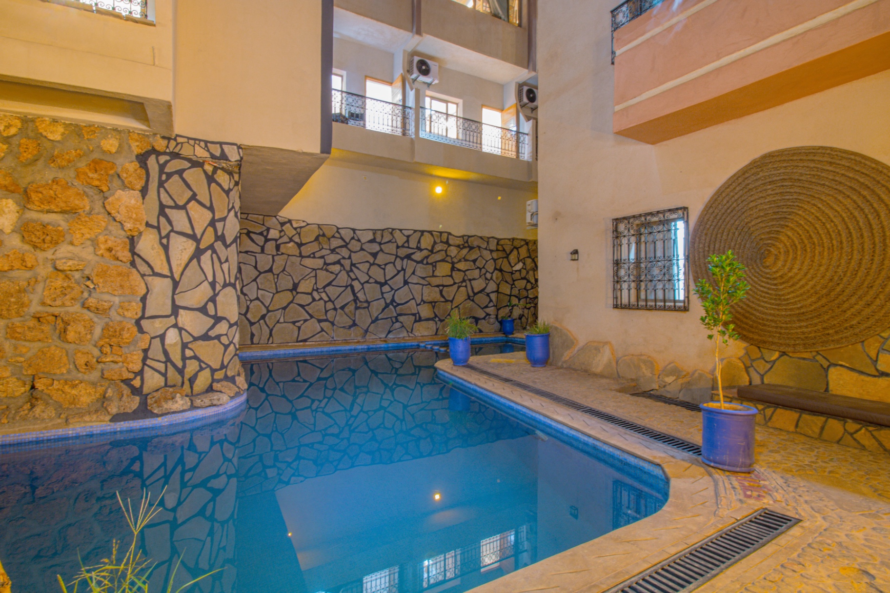 Courtyard swimming pool framed by stone walls and balconies at Riad Canyon Dades, Morocco